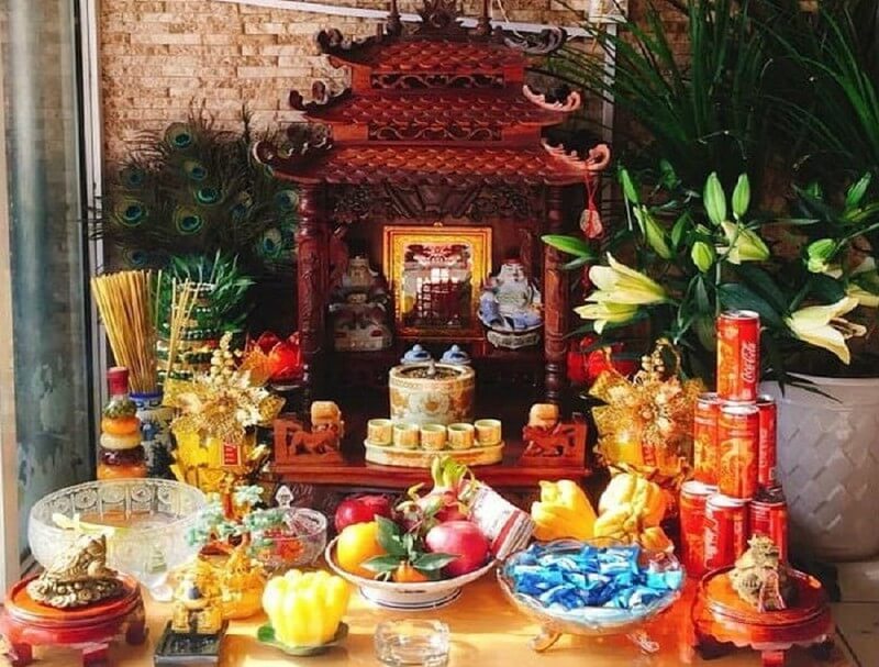 Trước bài vị, gia chủ bày bát hương trên khay vàng giấy, hai cây đèn nhỏ, và một khay nước chứa hai chén rượu cùng ba cốc nước, đặt hai bên bát hương